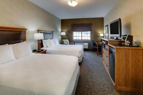 a hotel room with two beds and a flat screen tv at Stoney Creek Hotel Sioux City in Sioux City