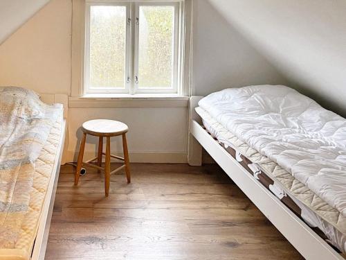 a bedroom with a bed and a stool and a window at 4 star holiday home in TORHAMN-By Traum in Torhamn
