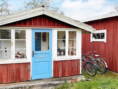 a red building with a blue door and a bicycle at 4 star holiday home in TORHAMN-By Traum in Torhamn