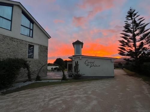 a building with a sunset in the background at Casal de pelaio in Barreiros