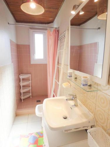 a bathroom with a sink and a toilet and a mirror at Le point du jour in Lit-et-Mixe