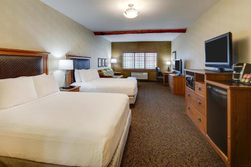 a hotel room with two beds and a flat screen tv at Stoney Creek Hotel Sioux City in Sioux City