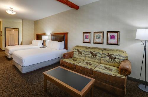 a hotel room with two beds and a couch at Stoney Creek Hotel Sioux City in Sioux City