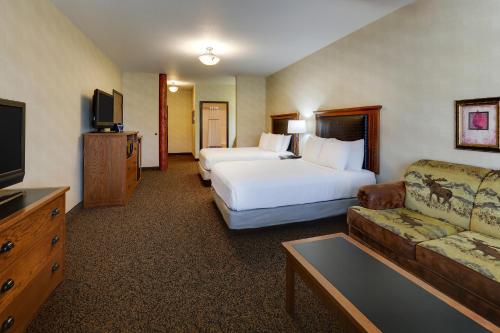 a hotel room with two beds and a couch at Stoney Creek Hotel Sioux City in Sioux City