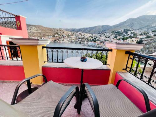 a table and chairs on a balcony with a view at Kleanthi and Kostas Studios in Symi