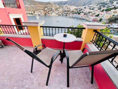 a table and chairs on a balcony with a view at Kleanthi and Kostas Studios in Symi