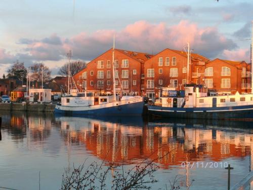 two boats are docked in the water in front of buildings at Ferienanlage Orther Reede, Fehmarn-Orth in Orth