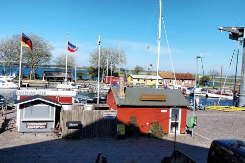 a marina with boats and a red building with flags at Ferienanlage Orther Reede, Fehmarn-Orth in Orth