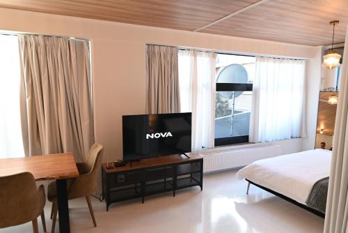 1 dormitorio con 1 cama y mesa con TV en Modern Downtown apartment + FREE parking en Larisa