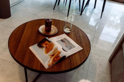 a wooden table with a book and a drink on it at Apartamenty Belni Hel Edyta i Maciej Wolak in Hel