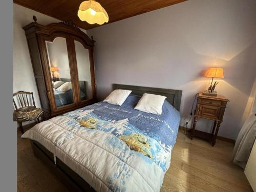 ein Schlafzimmer mit einem großen Bett und einem Spiegel in der Unterkunft Jouanon in Bias