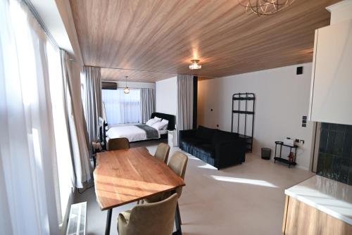 a living room with a table and a bedroom at Modern Downtown apartment + FREE parking in Larisa