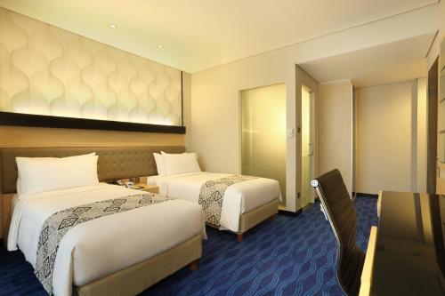 Un ou plusieurs lits dans un hébergement de l'établissement AI Hotel Jakarta Thamrin