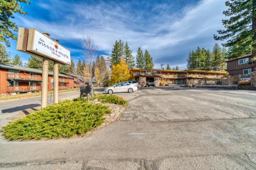 a parking lot at a hotel with a sign and a car at Moose and Maple Lodge in South Lake Tahoe