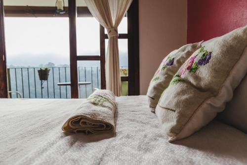 a bed with two pillows on it with a window at Hotel San Jorge in Tlatlauquitepec