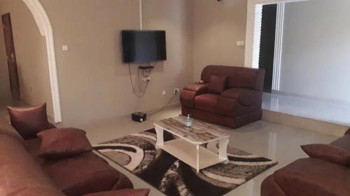 ein Wohnzimmer mit einem Sofa, einem Stuhl und einem Tisch in der Unterkunft Sohna's Paradise Residence 