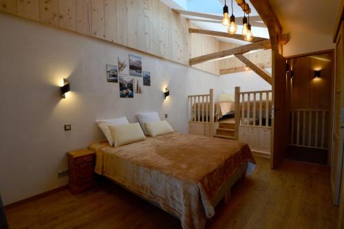 um quarto com uma cama num quarto com pisos em madeira em La Flémingîte em Scionzier