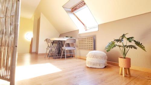 Cette chambre mansardée dispose d'une lucarne et d'une plante. dans l'établissement L'Evasion - Balcon - Fibre - Calme - RBNB, à Bollwiller