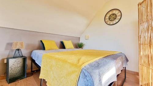 - une chambre avec un lit et une horloge murale dans l'établissement L'Evasion - Balcon - Fibre - Calme - RBNB, à Bollwiller