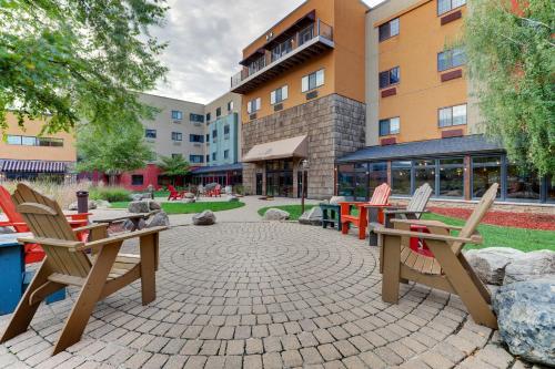 a patio with chairs and tables in front of a building at Stoney Creek Hotel Sioux City in Sioux City
