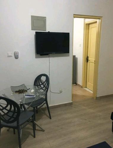 a living room with a table and chairs and a television at Lovely 1-bedroom rental unit for short stays. in Tema