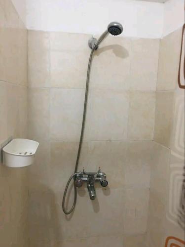 a shower with a hose in a bathroom at Lovely 1-bedroom rental unit for short stays. in Tema