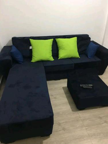 a black couch with green pillows in a room at Lovely 1-bedroom rental unit for short stays. in Tema