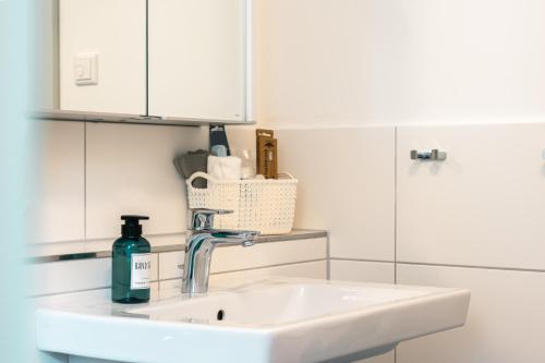 a white kitchen with a sink and a bottle of soap at Luxuswohnung am Steinhuder Meer - Tierfreundlich - A in Wunstorf