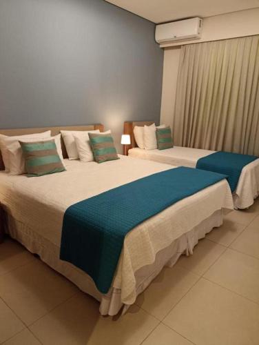 two beds in a hotel room withacers at THERMAS SÃO PEDRO RESORT in São Pedro