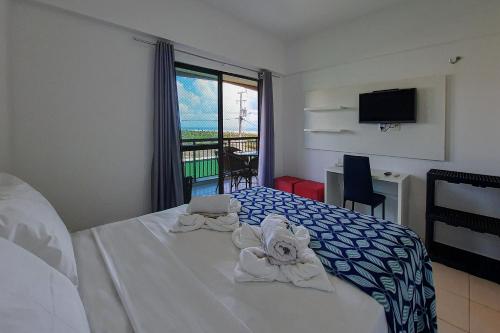 um quarto de hotel com uma cama com toalhas em Beverly Hills 2 Suítes Apto Completo 500m Praia em Aquiraz