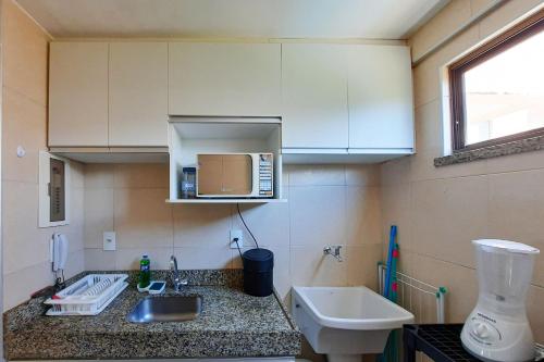 uma pequena cozinha com um lavatório e um micro-ondas em Beverly Hills 2 Suítes Apto Completo 500m Praia em Aquiraz