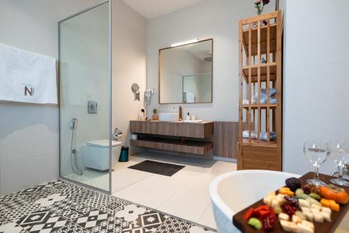 ein Badezimmer mit einer Badewanne, einem Waschbecken und einem Spiegel in der Unterkunft Nammos Experience in Amman