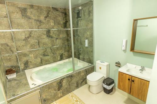 een badkamer met een bad, een toilet en een wastafel bij APARTAMENTOS MONACO in Baños