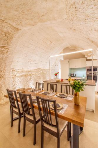une salle à manger avec une table et des chaises en bois dans l'établissement Gîte troglodyte - Troglo du Pontcher, à Montrichard
