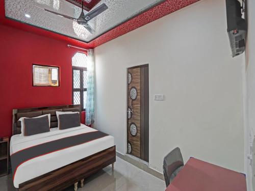 sypialnia z łóżkiem i czerwoną ścianą w obiekcie Collection O 81112 Hotel Joyous w mieście Ghaziabad