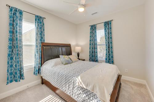a bedroom with a bed and two windows with blue curtains at Pet-Friendly Wilmington Home - 2 Mi to Riverwalk in Wilmington