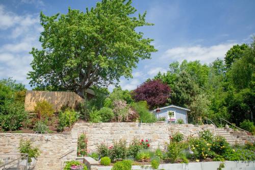 a garden with a stone wall and a tree at City-Appartements Am Wall in Goslar