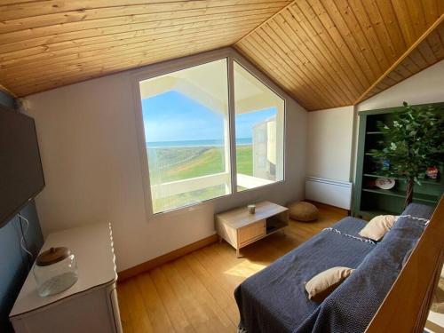 - une chambre avec une grande fenêtre et un lit dans un dortoir dans l'établissement Duplex vue mer entre Golf et Océan, à Saint-Jean-de-Monts