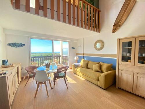un salon avec un canapé et une table dans l'établissement Duplex vue mer entre Golf et Océan, à Saint-Jean-de-Monts