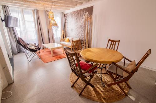 a room with a table and chairs and a living room at LE DUPE in Brissac-Quincé