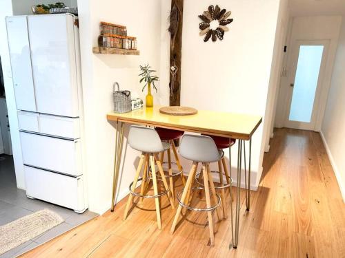a kitchen with a counter with stools and a refrigerator at One bedroom apartment and CARPORT close to beaches, airport,CBD in Sydney