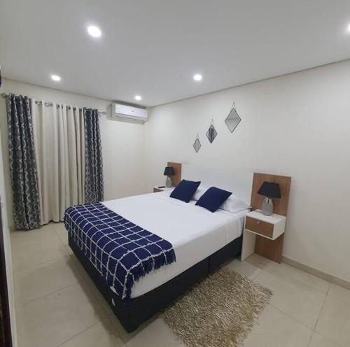 a bedroom with a bed with a blue and white blanket at Apartamento nuevo, Asunción. in Asuncion