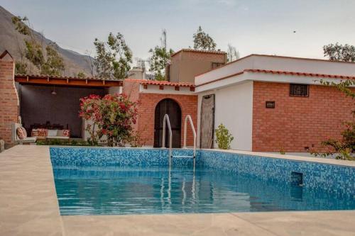 a swimming pool in front of a house at Amplia Casa de Campo con Piscina en Cieneguilla in Cieneguilla