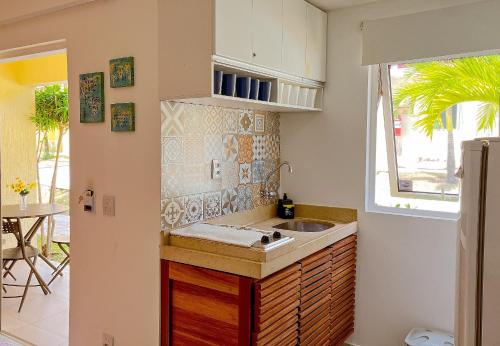 a small kitchen with a sink and a window at Solar Água Pipa- Summer Pipa in Pipa