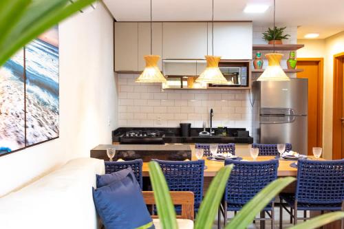 a kitchen and dining room with a table and chairs at Casa Lanai - Perto de Restaurantes e da Capela Milagres - Internet 300 Mbs in São Miguel dos Milagres
