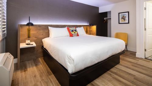 a bedroom with a large white bed in a room at The Catrina Hotel in San Mateo