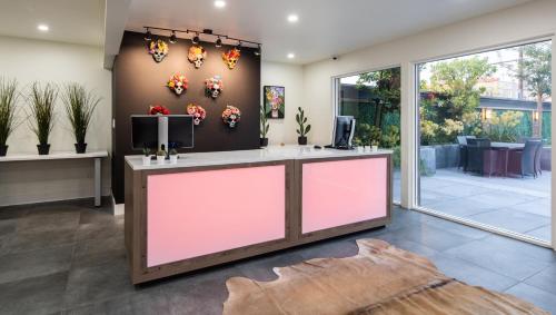 a lobby with a reception desk with a pink front at The Catrina Hotel in San Mateo
