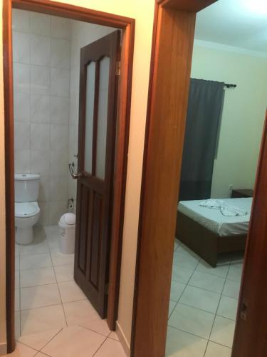 an open door to a bathroom with a toilet and a bed at Fogo Morabeza Tur in São Filipe