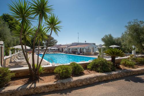 una piscina con palme in un resort di Centro Vacanze Piccolo Friuli a Vieste