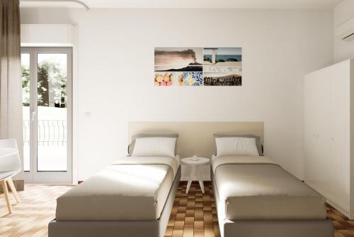 2 camas en una sala de estar con mesa en Residence Villa Giardini, en Giardini Naxos